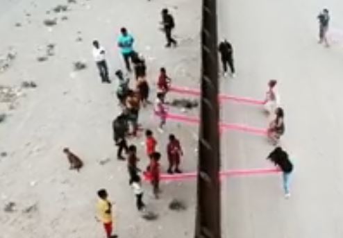 Pink Seesaws Slotted Through The US-Mexico Border Wall
