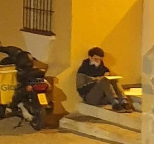 Student praised as he's snapped studying on steps while wating to make home delivery