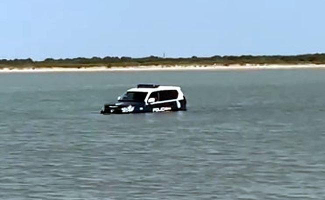 National Police vehicle submerged on Cadiz beach as tide comes in