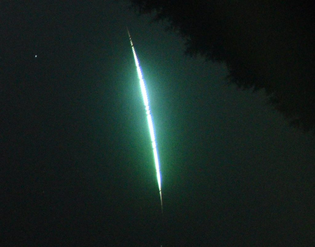 A meteor producing green light