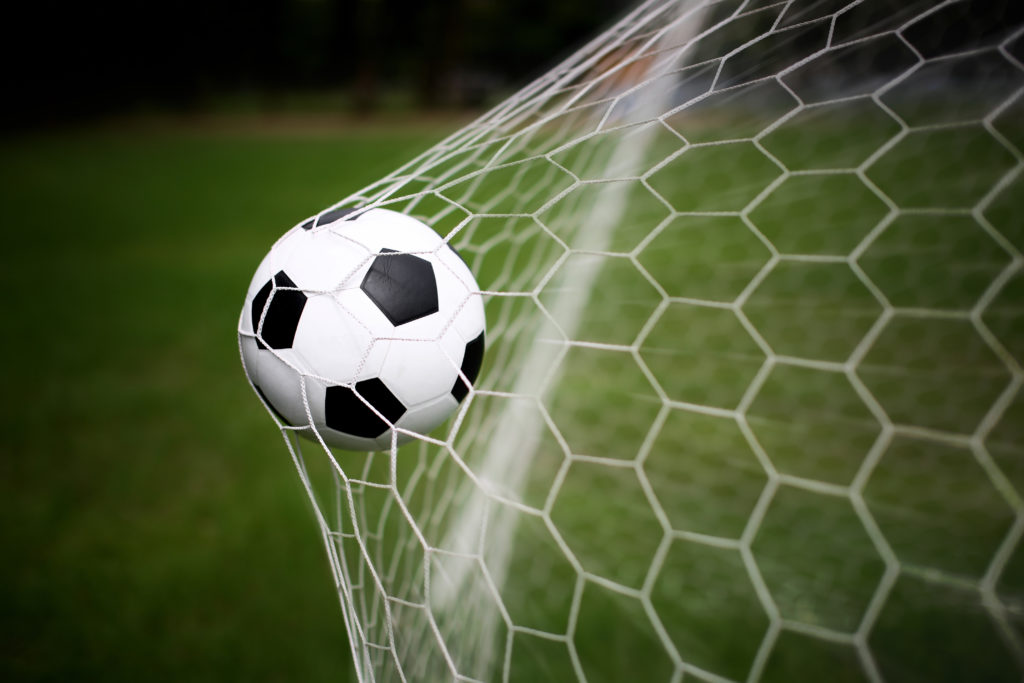 Image of a football hitting the back of the net.