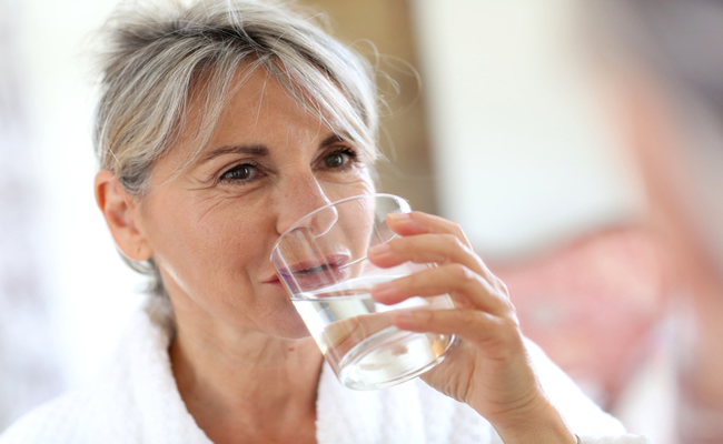 Image of a woman drinking a glass of water.
