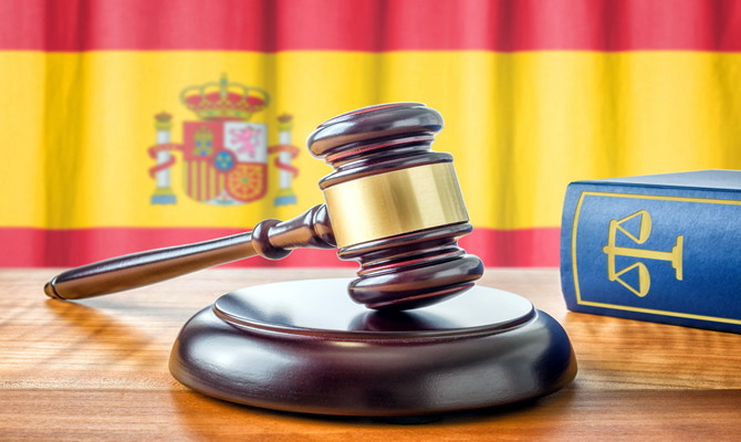 Image of a judge's gavel with flag of Spain.