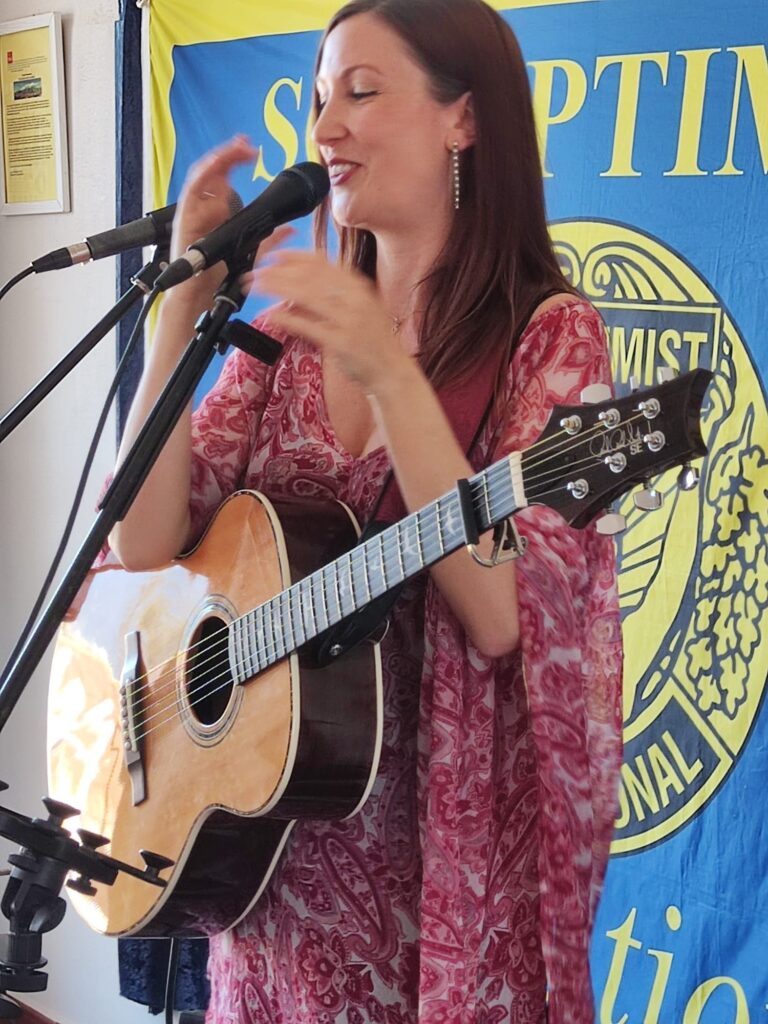 singer Sandie Ann plays guitar and sings at Sorptimist International fundraiser