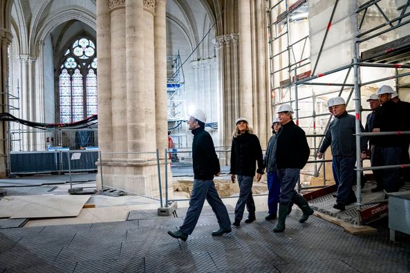 Emmanuel Macron walks in Notre Dame as he tries to cool tensions.