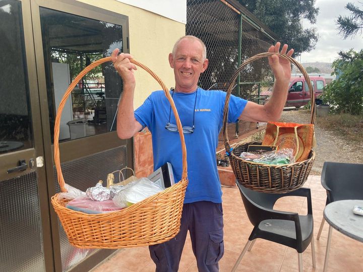 man poses with raffle baskets