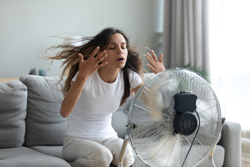 girl cooling down in front of a fan