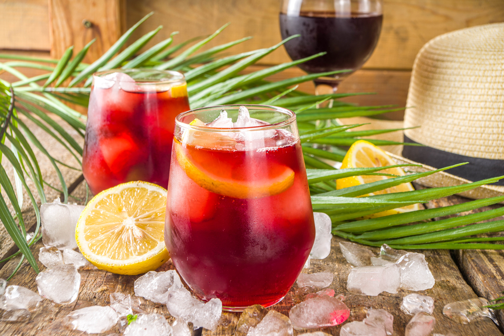 Tinto de verano on a wooden table with a hatt, ice and fruit