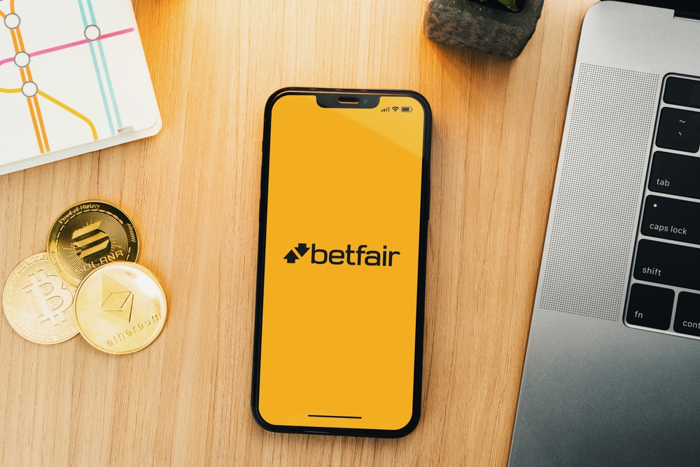 Betfair app open on a mobile phone on a wooden desk