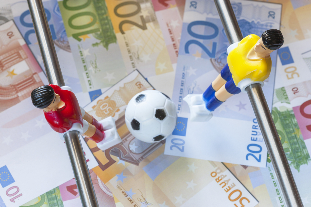 Image of toy football players standing on euros.