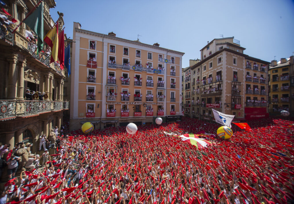 Image of hundreds of people draped in red celebrating san fermin