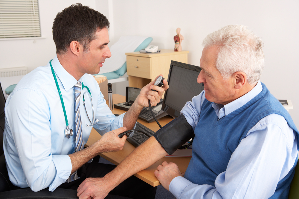 Image of doctor taking a patient's blood pressure.