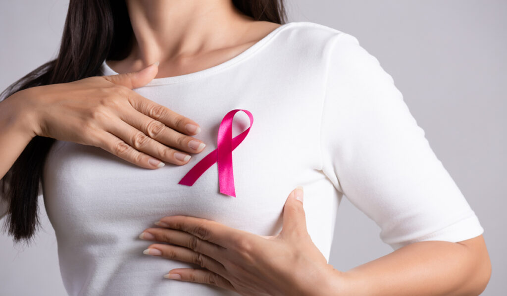 Image of a woman wearing a pink ribbon in support of breast cancer.