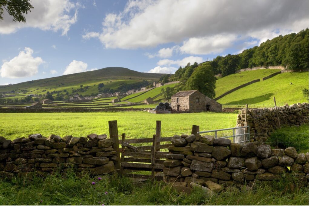 Scenic view of the UK countryside with roaming hills and at front of picture a wooden style