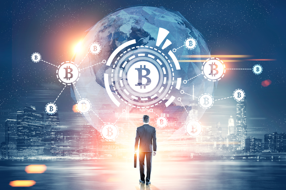 A man with a briefcase walking towards a silhouette of the world with a bitcoin symbol