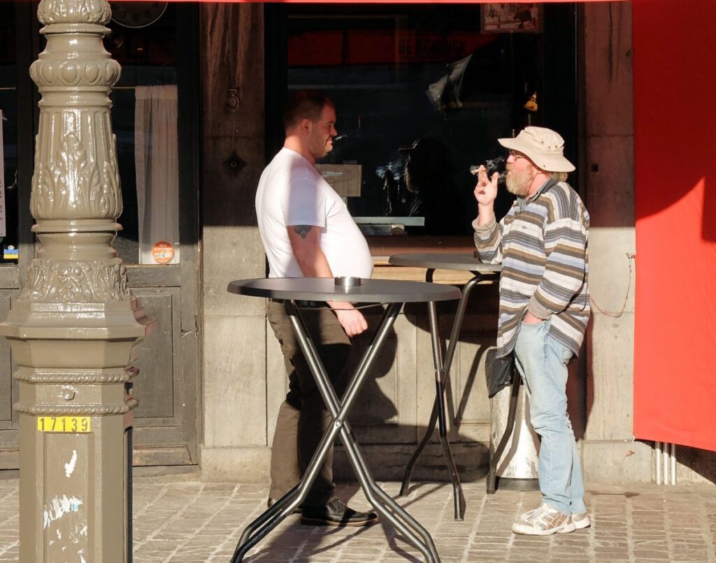 Men standing smoking on terrace
