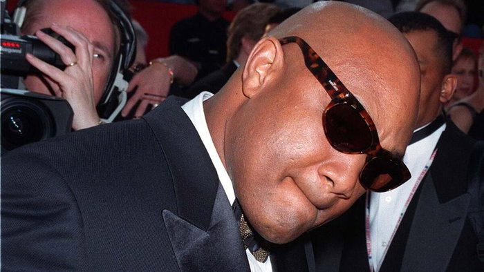 George Foreman wearing sunglasses and posing for photographers at a public event