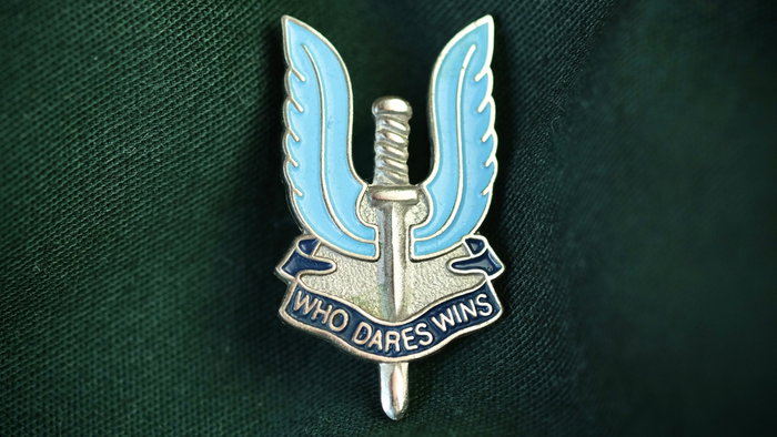 He "who dares wins" - SAS Special Air Service metal pin badge on army military uniform taken in the UK, October 2023.