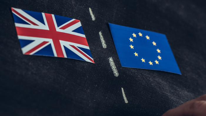 UK and EU flags separated by chalk line on blackboard, symbolising Brexit division