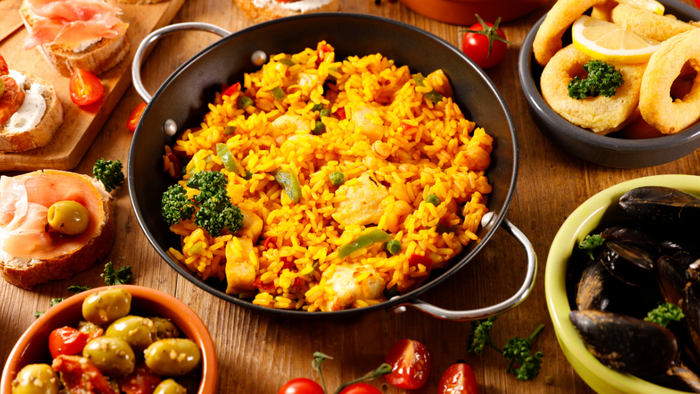 Seafood paella and tapas on a rustic table