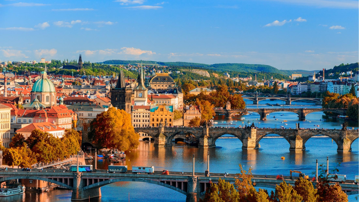 View of multiple historic bridges and colourful buildings along the Vltava River in Prague during autumn