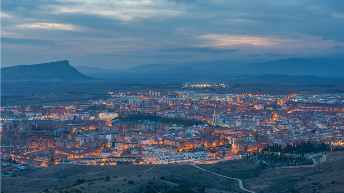 Aerial view of Soria at dusk, surrounded by hills and mountains.
