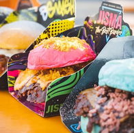 Four colourful smash burgers with orange, pink, and blue buns.