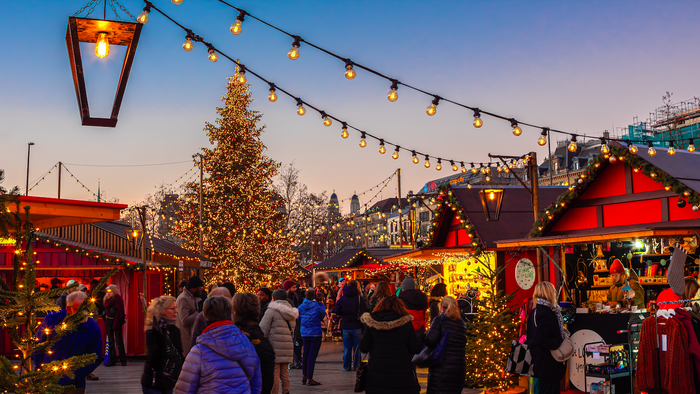 A christmas market surrounded by lights and and people