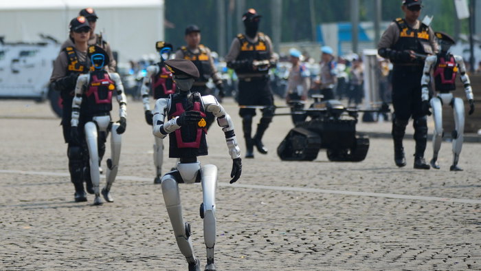 Humanoid police robots walking alongside human officers in Indenosia during a public demonstration, symbolising the rise of AI in law enforcement.
