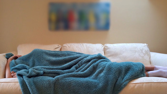 feeling cold on the sofa, wrapped in a blanket