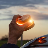 Hand placing a V16 beacon on the roof of a car