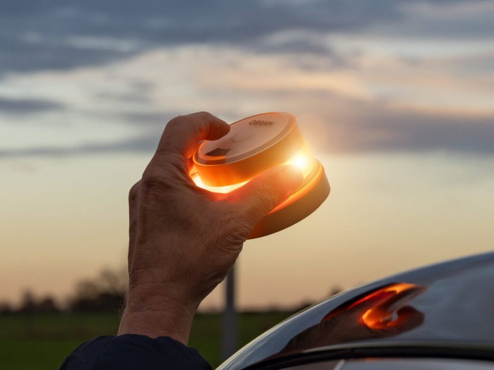 Hand placing a V16 beacon on the roof of a car