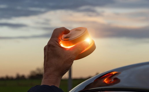 Hand placing a V16 beacon on the roof of a car