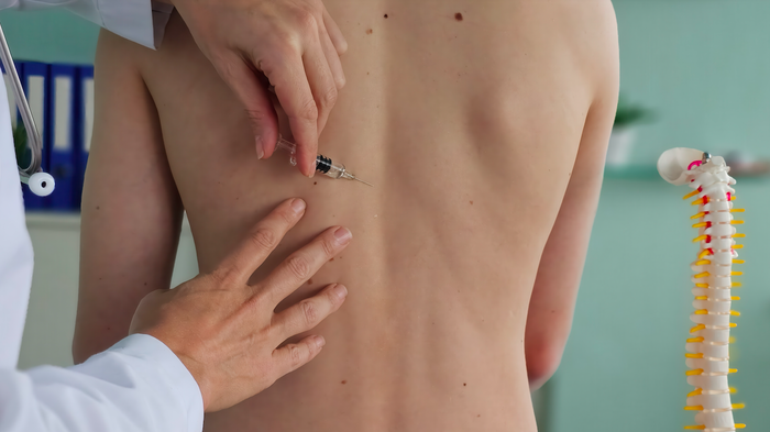 Woman receiving injection of ozone therapy into her spine