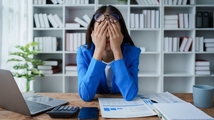 Employee looking stressed out, signifying consequence of being overworked