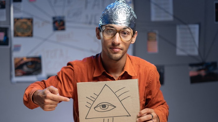 A man wearing a tin foil hat, symbolising he believes in conspiracy theories