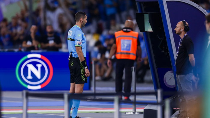 Referee looking at a VAR screen during a football match