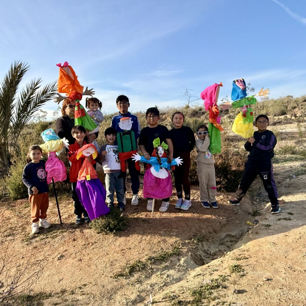 Children from Mojacar stand with the Vieja piñatas made for Dia de la Vieja
