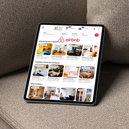 Airbnb app displayed on a tablet showing holiday rental listings in Spain