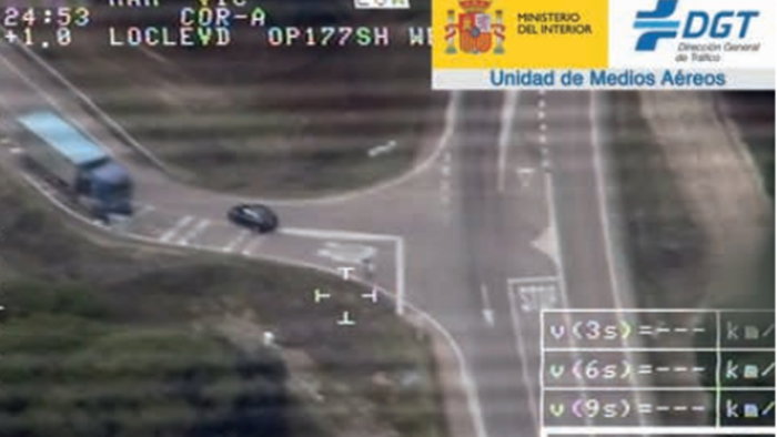 DGT aerial image showing car cutting into opposite lane at junction and forcing truck to brake in Spain