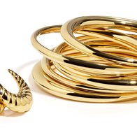 View of a pile of Gold bracelets and a pair of Gold earrings