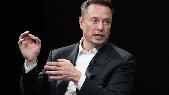 Elon Musk speaking during a public event, discussing artificial intelligence and the future of work.