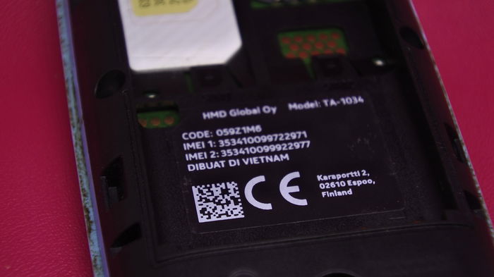 Close-up of a smartphone battery compartment showing the device’s IMEI identification number label.