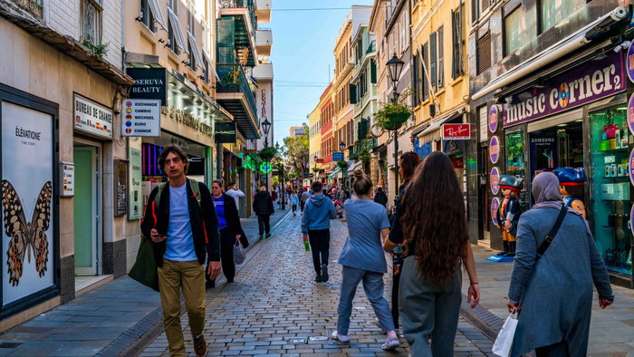“People walking along Gibraltar’s Main Street shopping district.”