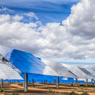 Solar panels in a field with cloudy sky