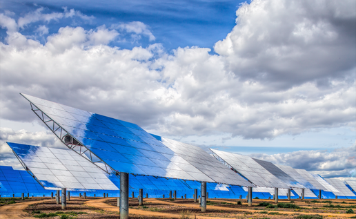 Solar panels in a field with cloudy sky