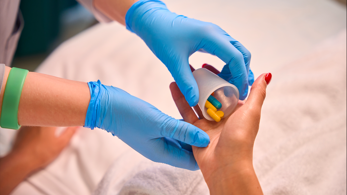 Doctor handing medication in a patients hand