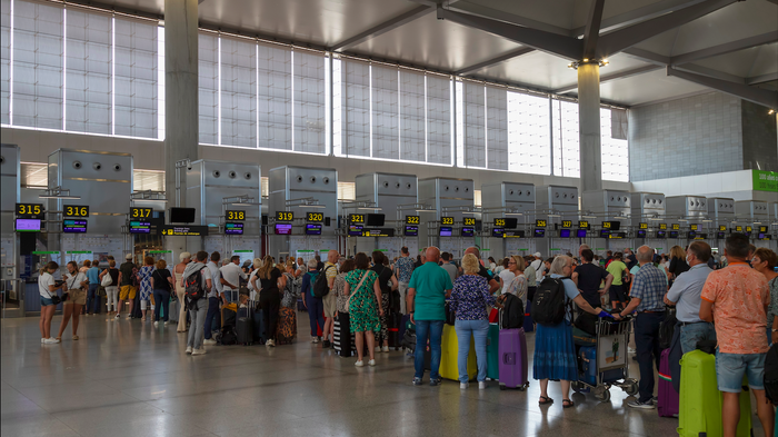 Passengers queueing at a check in point at an airport
