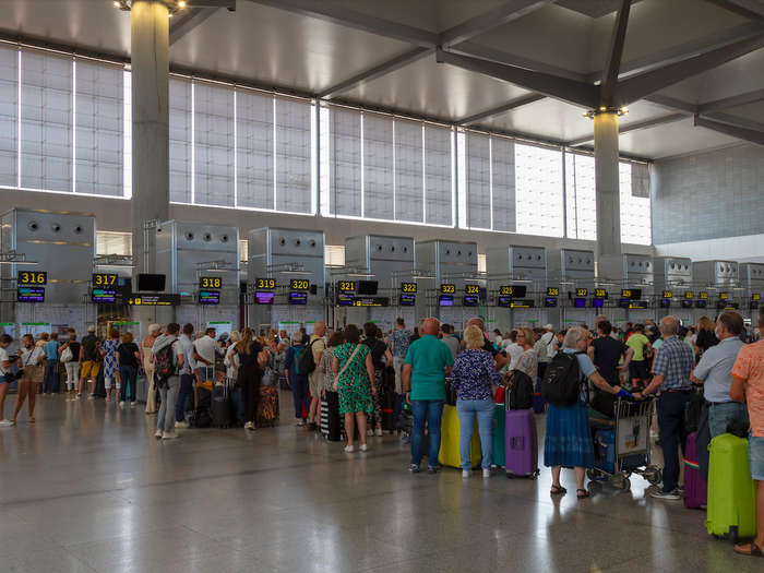 Passengers queueing at a check in point at an airport
