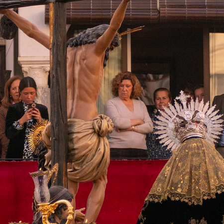 People watching a religious procession from a balcony